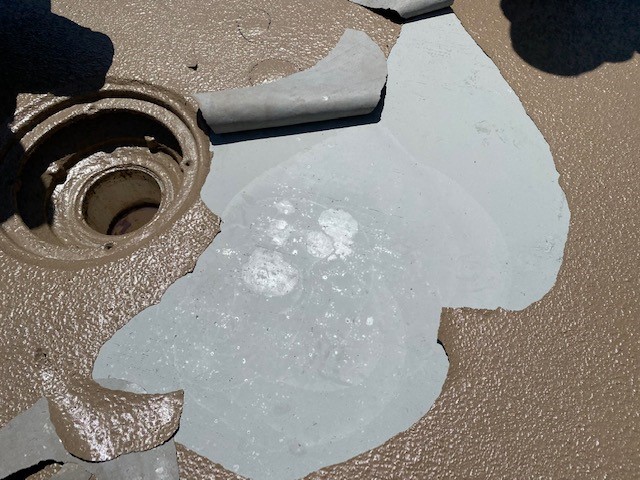 Peeling of coating from concrete floor.