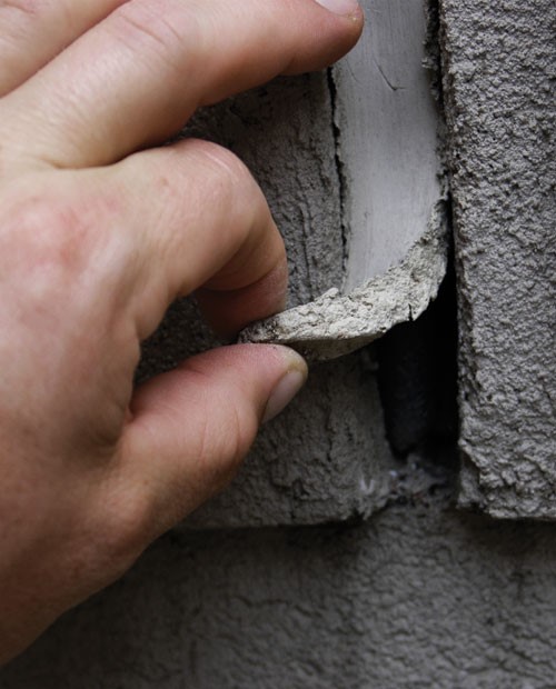 Person peeling off piece of sealant.